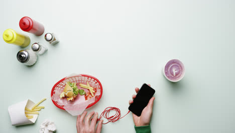 top view man connecting headphones to mobile phone at american diner fast food restaurant hands from above - red epic dragon