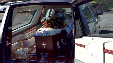 closeup shot of a funeral casket in a hearse or chapel or burial at cemetery