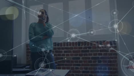 animation of network of connections over biracial businesswoman talking on smartphone