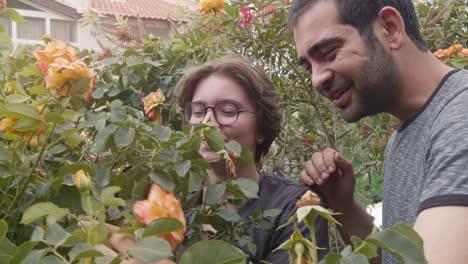 young girl and man examines flowers with a magnifying glass