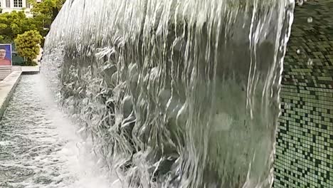 Close-up-or-fountain-water-drops-to-small-pool-in-the-city