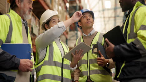 warehouse workers discussing inventory with a tablet