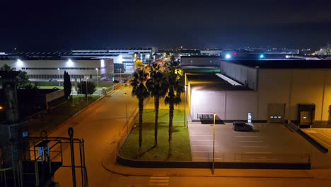 night view of industrial complex with palm trees