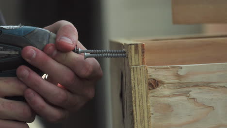 Closeup,-of-Construction-Worker-Hands-Drilling-Two-Screws-Into-Wood-with-Power-Drill