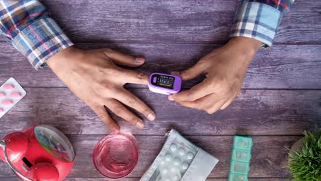 person using pulse oximeter at home