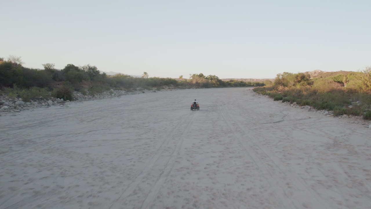 Uomo in moto che si allontana dalla telecamera
