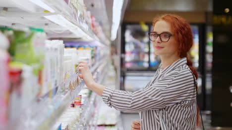 Kaukasische-Junge-Frau-Wählt-Joghurt-In-Einem-Supermarkt