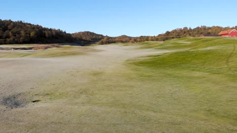 Low-altitude-backwards-drone-flight-at-Golf-course-in-Kallered,-Molndal-in-Sweden