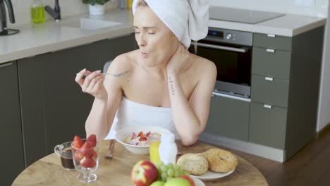 bella mujer de mediana edad sentada en su cocina por la mañana