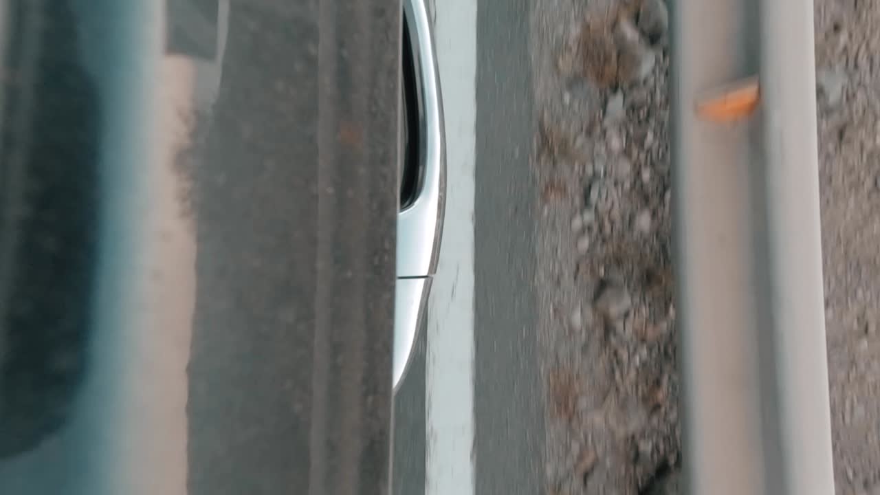 슬로우 모션으로 빠르게 지나가는 스포츠카의 세로 샷