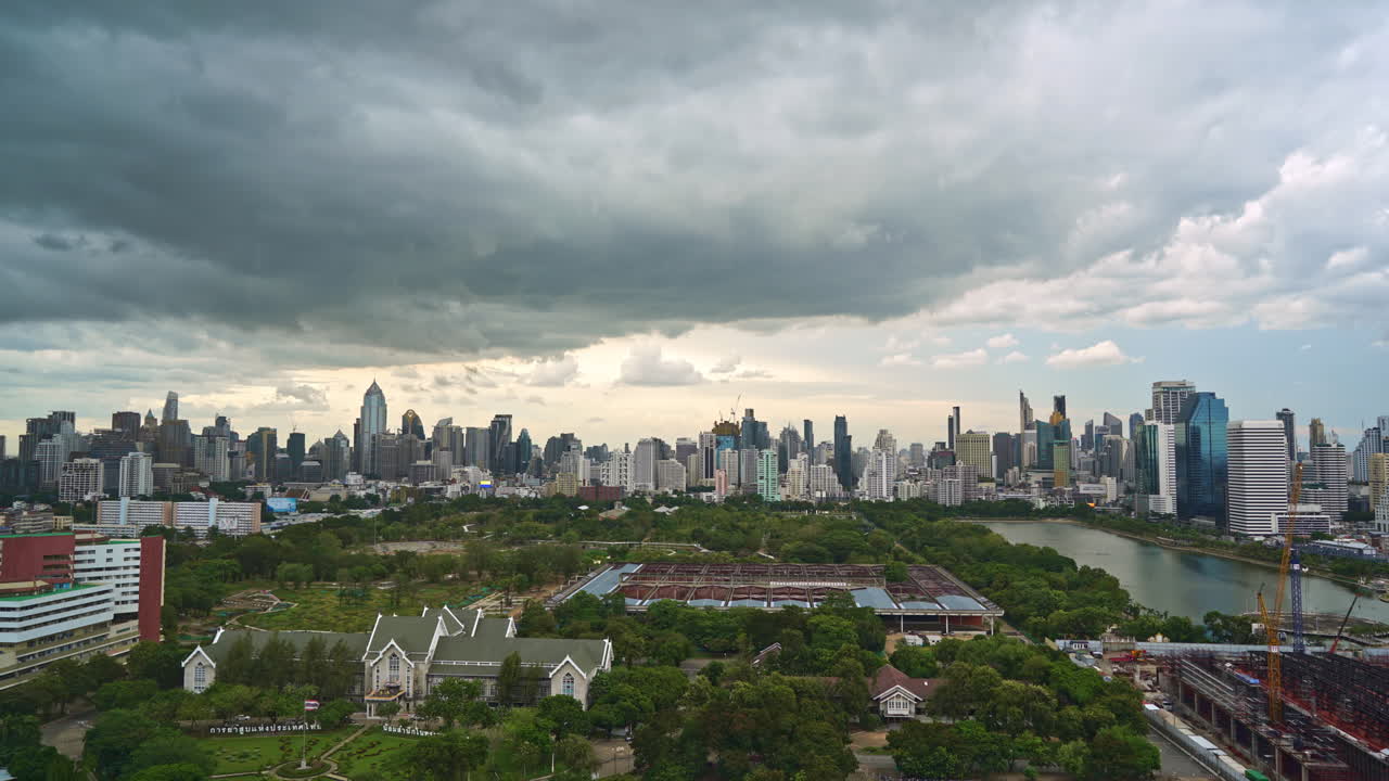 fuertes nubes de lluvia que se forman sobre el parque y el lago benjakitti del centro de la ciudad, horizonte de cloudscape en bangkok tailandia al atardecer, sitio de construcción del centro nacional de convenciones reina sirikit time-lapse