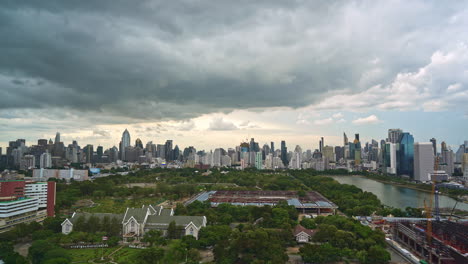 Fuertes-Nubes-De-Lluvia-Que-Se-Forman-Sobre-El-Parque-Y-El-Lago-Benjakitti-Del-Centro-De-La-Ciudad,-Horizonte-De-Cloudscape-En-Bangkok-Tailandia-Al-Atardecer,-Sitio-De-Construcción-Del-Centro-Nacional-De-Convenciones-Reina-Sirikit-Time-lapse