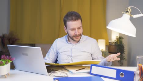 home office worker man looking at the file angrily.