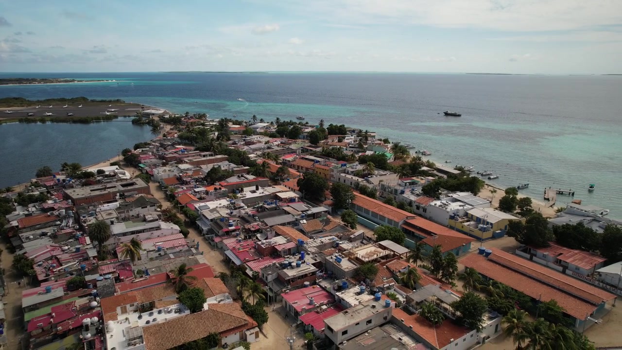 Vista aérea da vila de Gran Roque mostrando telhados coloridos, linha costeira e águas calmas do oceano