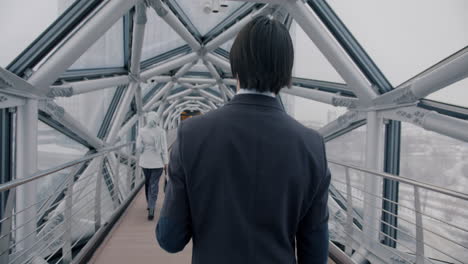 business people walking on a modern city bridge