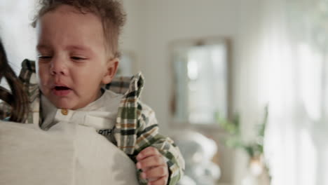 una madre sosteniendo a su adorable bebé, que está llorando