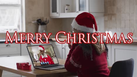 Animation-of-merry-christmas-text-over-woman-with-santa-hat-on-laptop-video-call-with-family