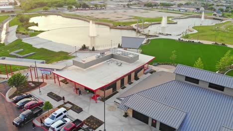 Circling-up-and-away-from-a-downtown-restaurant-that-has-a-perfect-view-of-three-large-fountains-and-their-pool-as-part-of-a-great-small-town-development