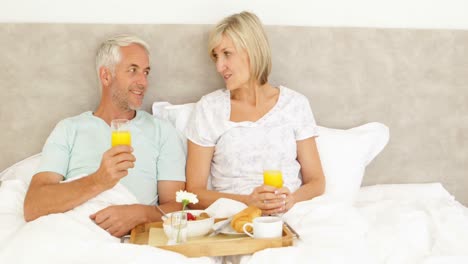 pareja disfrutando del desayuno en la cama juntos