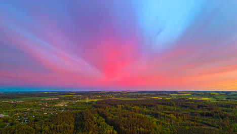 colorful sunset sky over countryside town with lush trees. timelapse