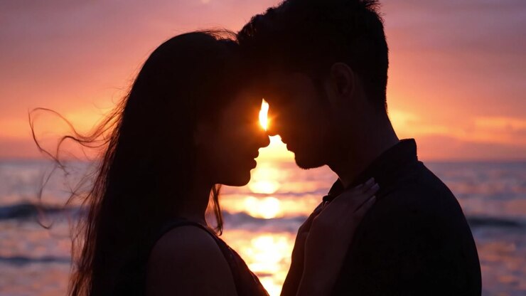 Une étreinte sereine au coucher du soleil : capturer un moment romantique entre deux amoureux en silhouette contre l'horizon doré de l'océan au crépuscule