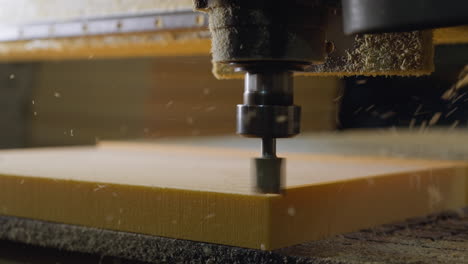 máquina de corte cnc en funcionamiento en material de espuma, con dispersión de partículas finas