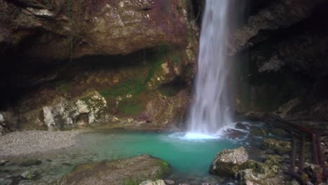 catarata de cueva con piscina de color turquesa