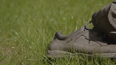 Dolly-of-a-worn-hiking-and-torn-shoes-in-a-grass-field