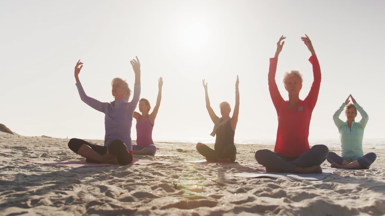 Sahilde yoga yapan atletik kadınlar