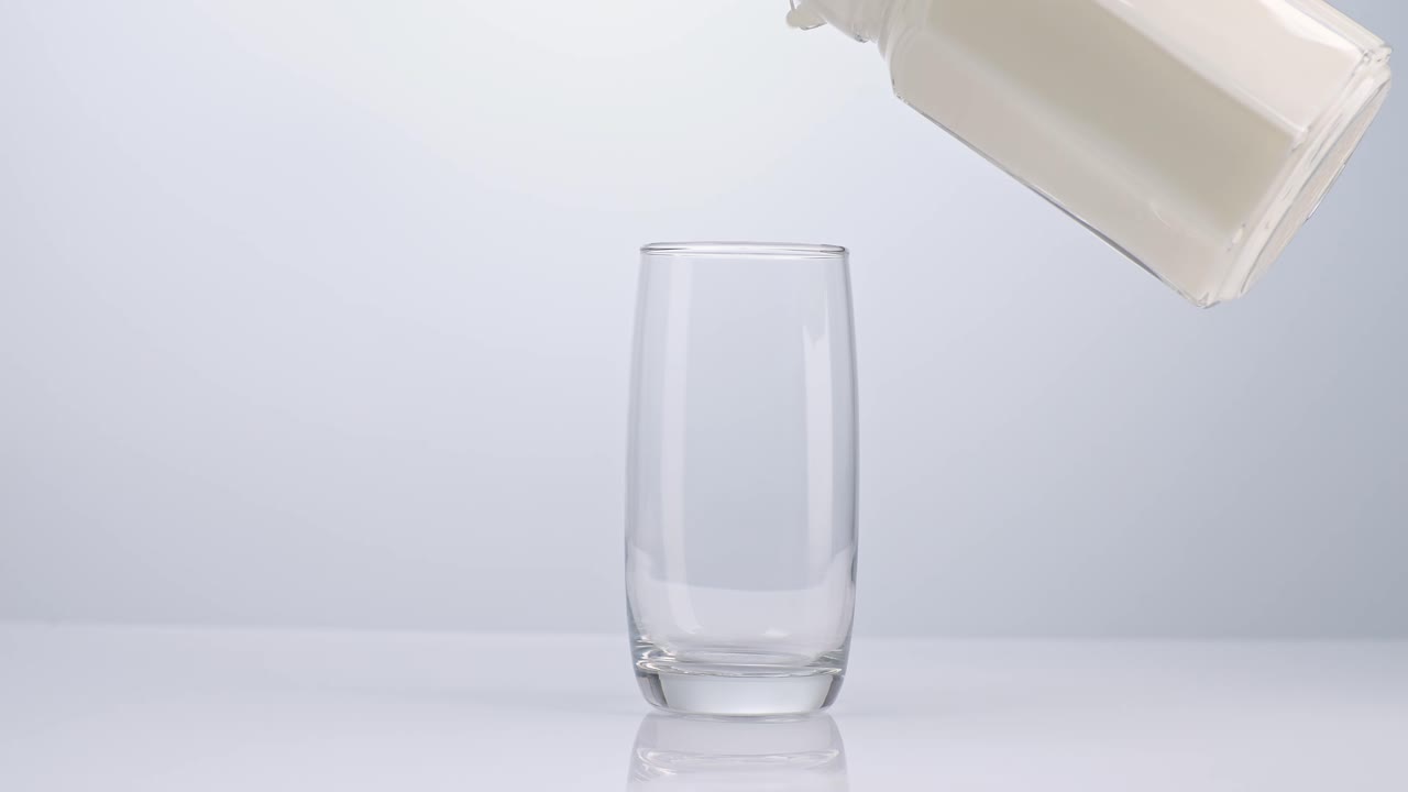 색 배경 에 있는 음료 컵 에 우유 가 여 있다