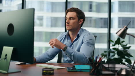 office manager frustrated looking on computer monitor sitting at desk close up