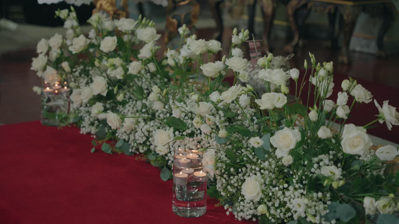 Elegante composizione floreale bianca con candele per decorazioni di cerimonie