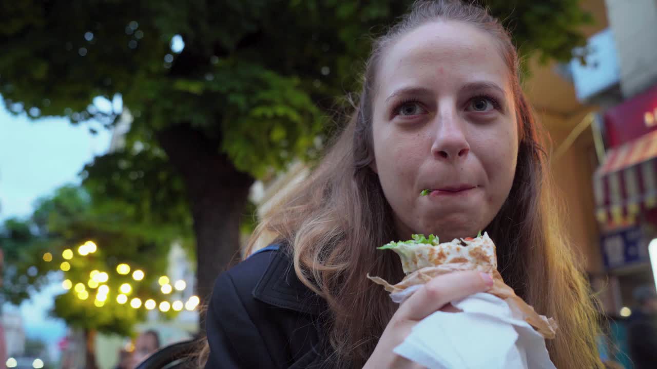 UGC style video of a woman having a casual falafel lunch on the go in the vibrant streets of Sofia Bulgaria