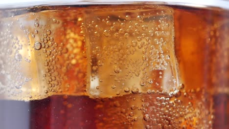 verter refrescos en un vaso con un cubo de hielo