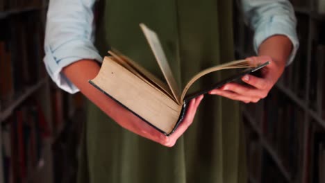 sección media de una colegiala volviendo un libro en la biblioteca