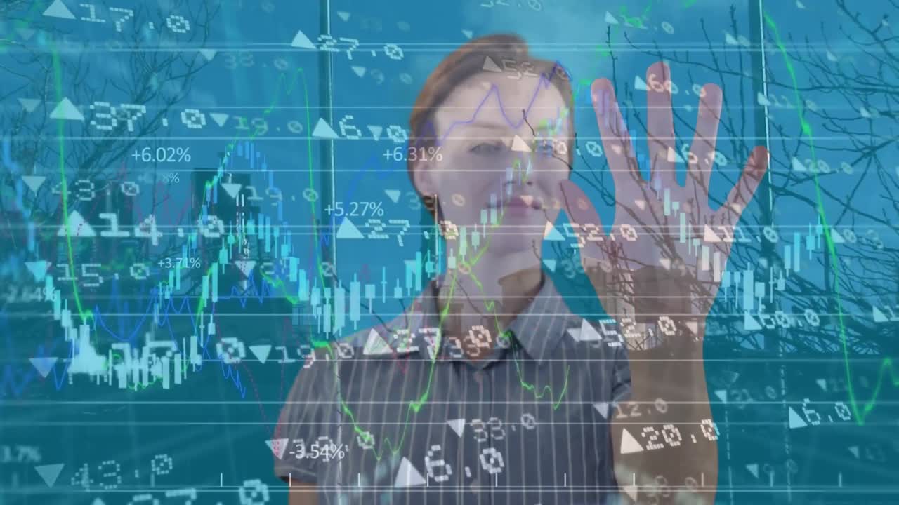 Animation of graphs, numbers and smiling caucasian woman looking hand over buildings and bare tree