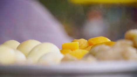 vista de cerca, plato humeante de patatas, verduras y tufu, fondo borroso