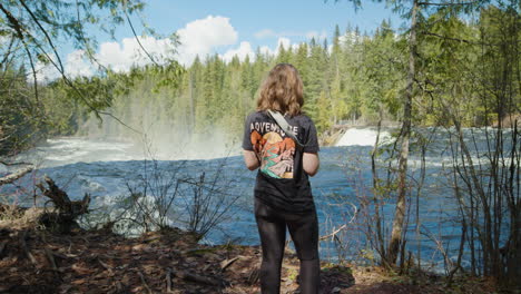 Back-view-of-woman-admiring-scenery-near-Dawson-Falls-on-sunny-day