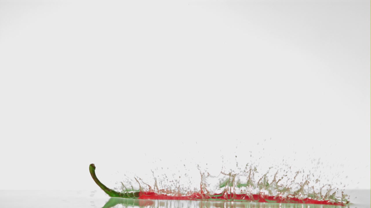 Red Chili Pepper Falling and Splashing into Water in Slow Motion