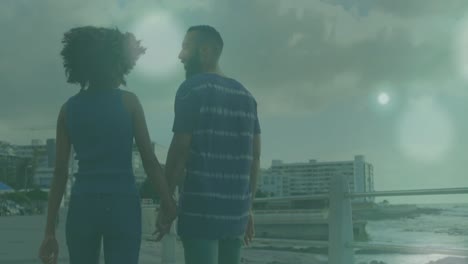 animation of glowing spots over diverse couple holding hands