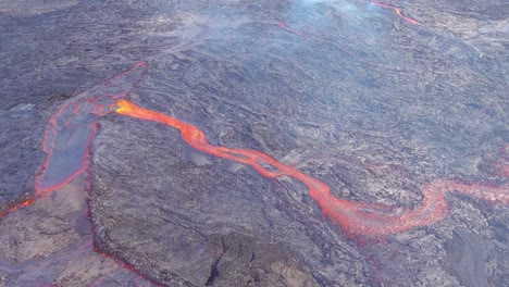hermosa toma aérea de ríos de lava que fluyen cerca de la erupción explosiva volcánica del volcán fagradalsfjall en islandia