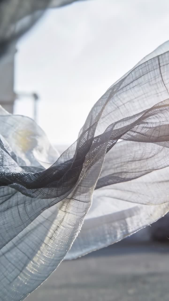 Vertikales Video: Eine Brise lässt dünnen grauen Stoff am Fenster wehen und zeigt dessen Webart und Transparenz