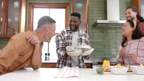 Happy-diverse-male-and-female-friends-preparing-food-together-in-kitchen