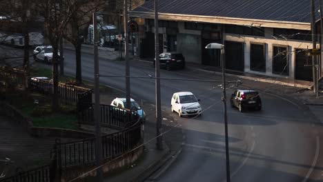 algunos vehículos pasando por una pequeña calle en un pequeño país