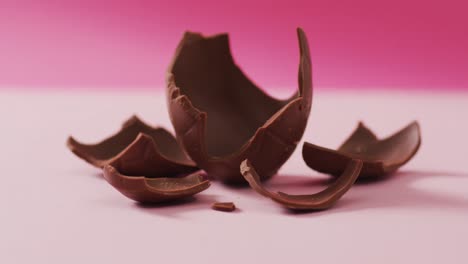 video of chocolate easter egg in pieces on a pink surface