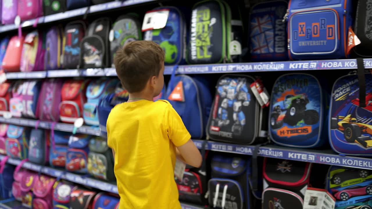 Boy choosing school supplies. Young boy choosing school stationery in supermarket