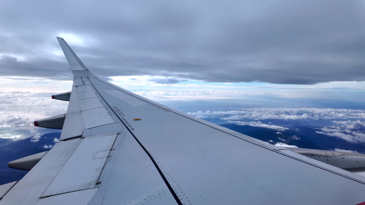 View from an airplane window of the aircraft wing in the clouds