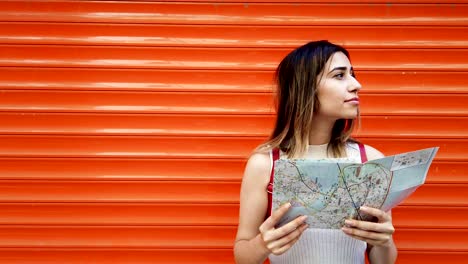 slow motion:beautiful young girl looks at map of istanbul with orange,red background