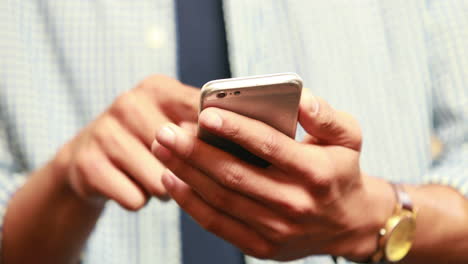 Close-up-view-of-casual-businessman-using-smartphone