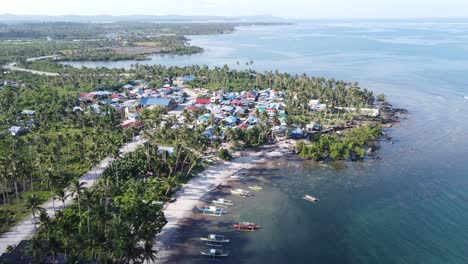 fishing boats and cabitoonan seaside beach village on coast of siargao island